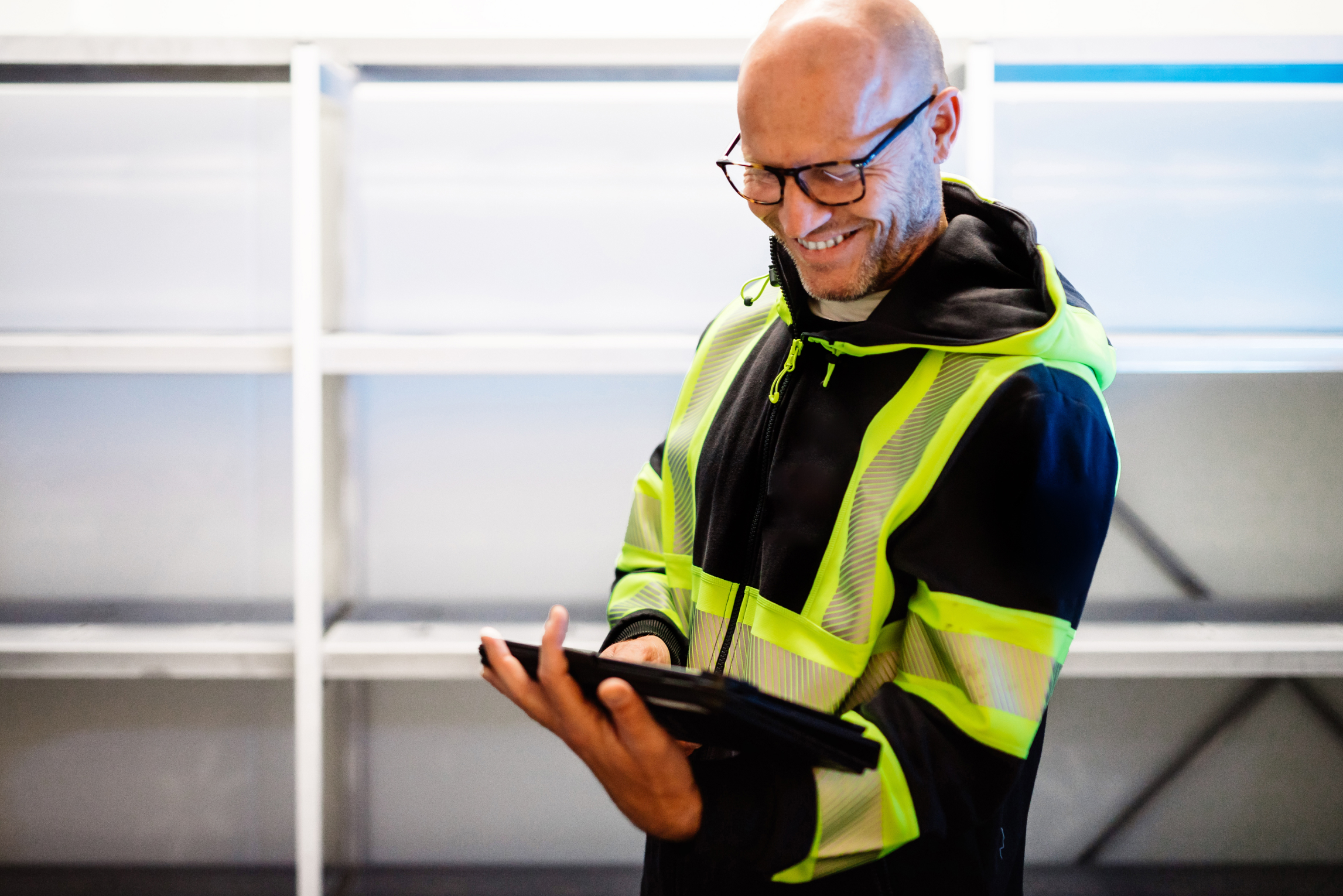 En man som ler och tittar på sin padda