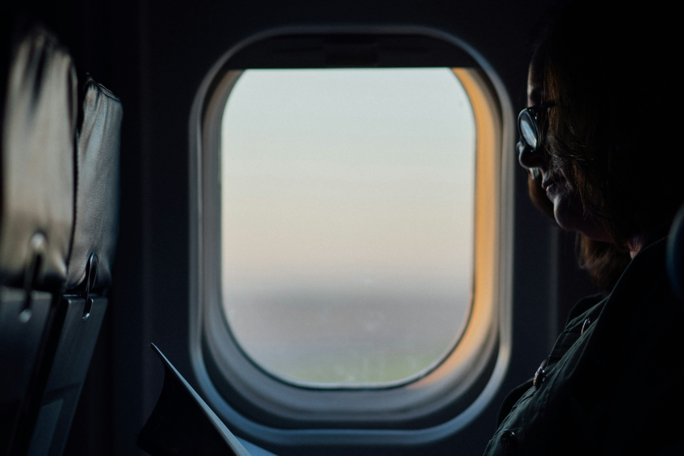 En äldre man som sitter vid ett flygplansfönster